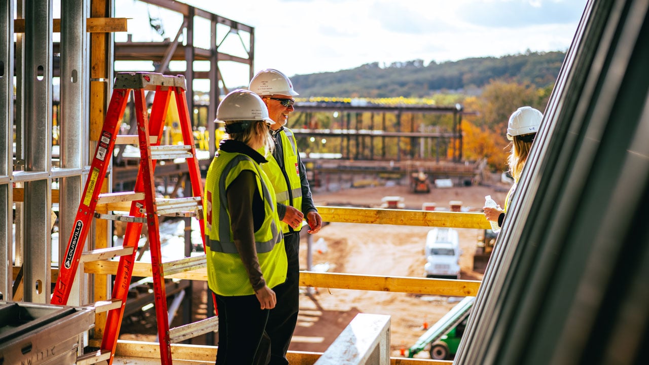 Construction workers talk and smile on site.