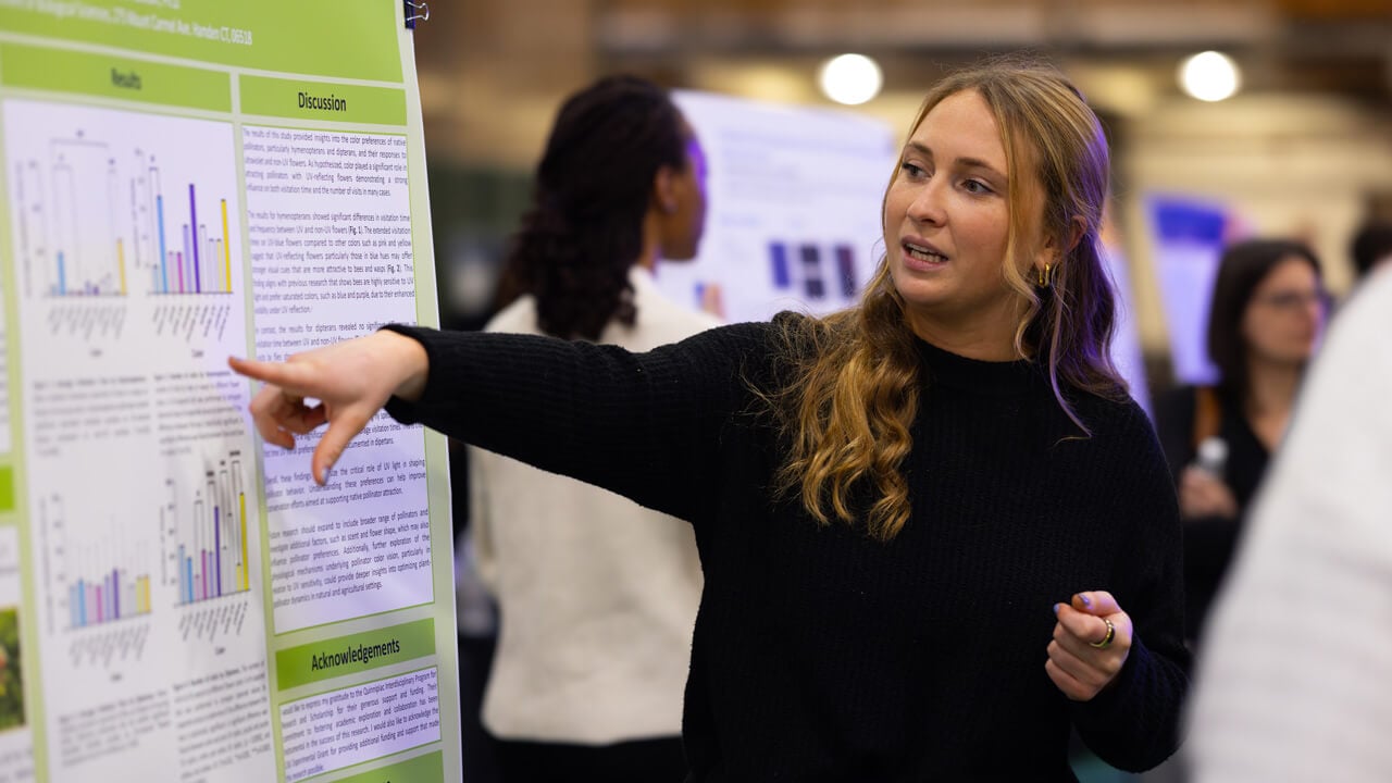 Biology major Louise Bacon explains her research at annual Exploratorium.