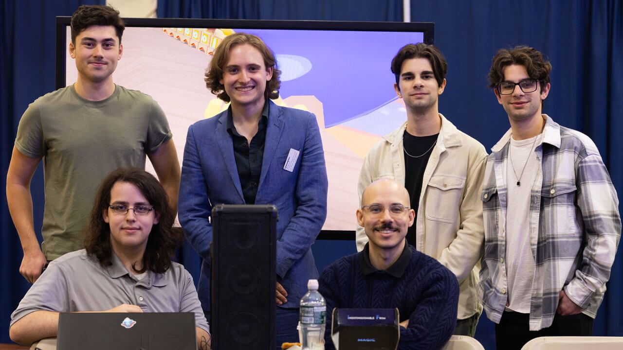 A group of five students pose and smile for a photo