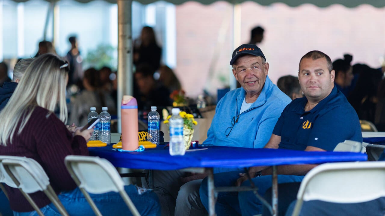 A family sits at a table during the bobcat welcome celebration.