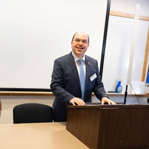 Dean of the School of Computing and Engineering, Taskin Kocak speaks at a podium.