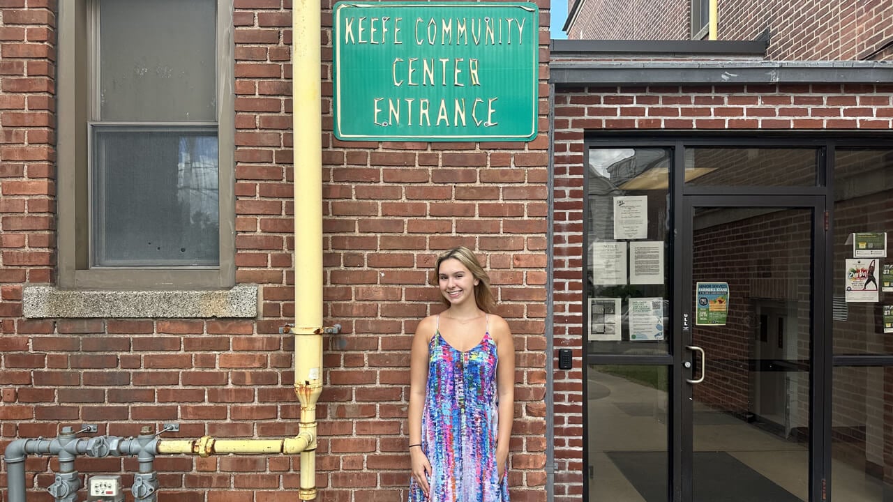 Jessica VanOss stands in front of Keefe Community Center sign