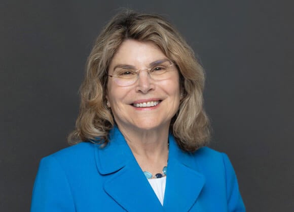 Robyn Gershon smiling for a headshot in a blue blazer.