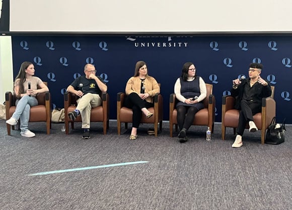 A panel of students, faculty and staff speak in the Mount Carmel Auditorium.