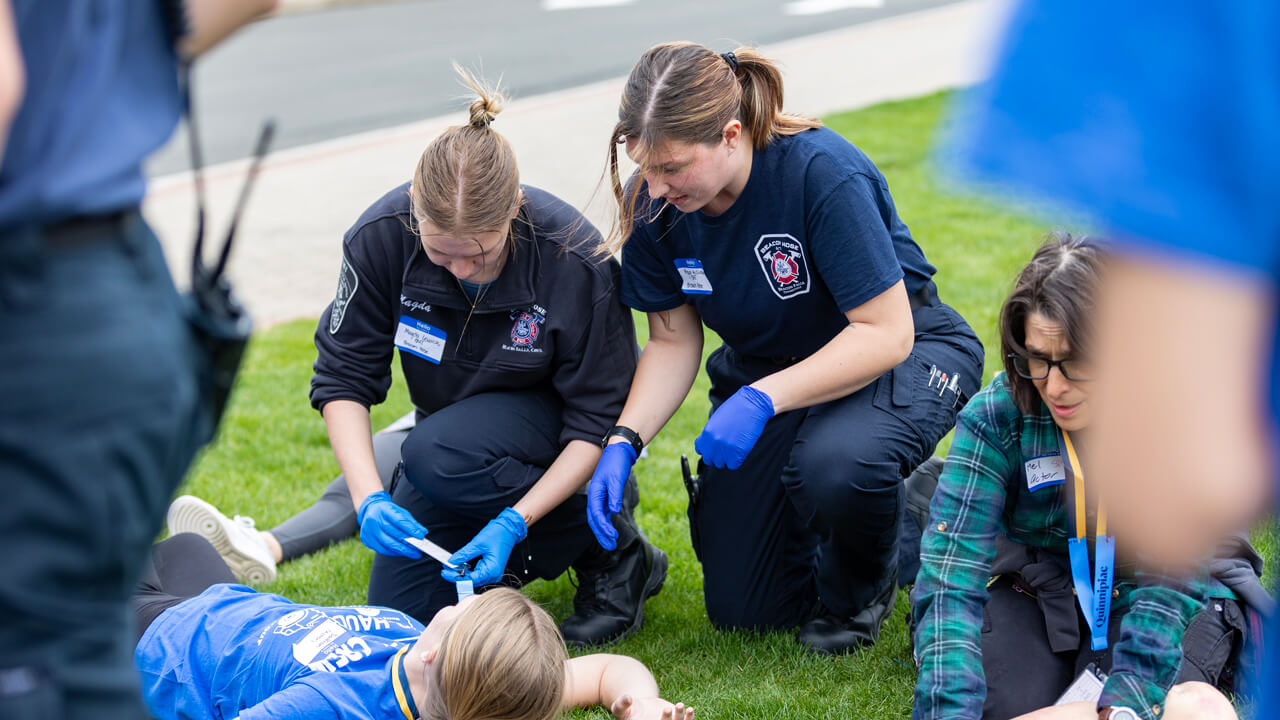 Two students helping girl in mass casualty incident drill