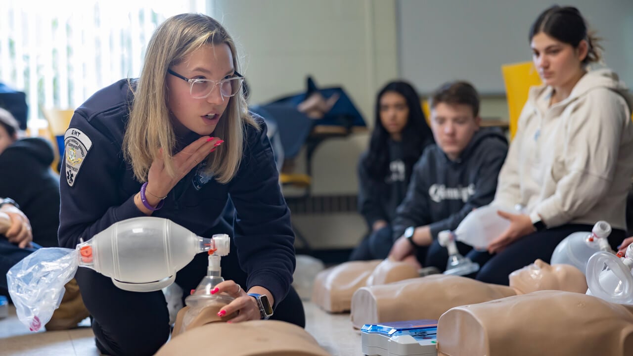 EMT teaching students CPR on a dummy