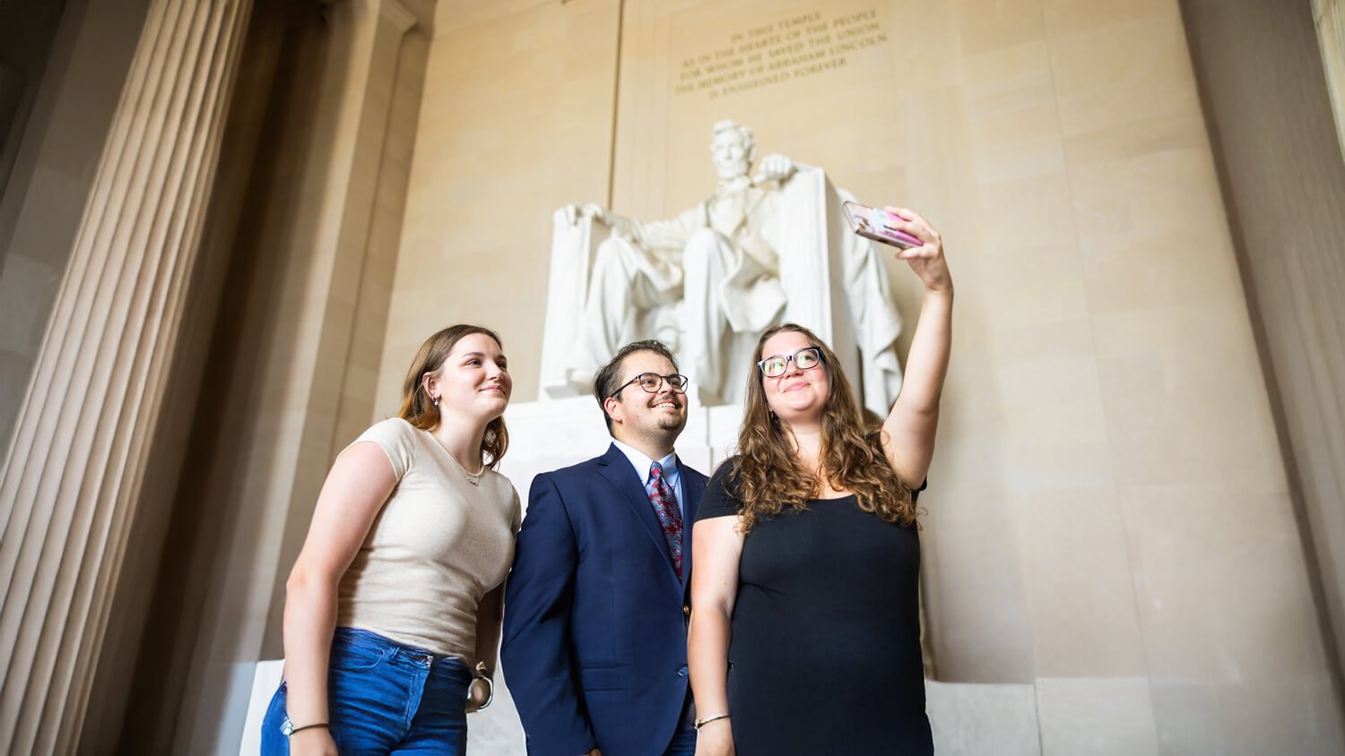 Quinnipiac students pose in front of a statue in Washington, D.C.