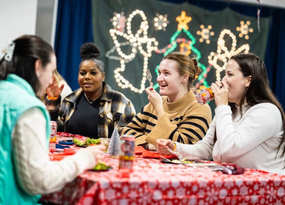 Individuals sitting at a table talking to each other