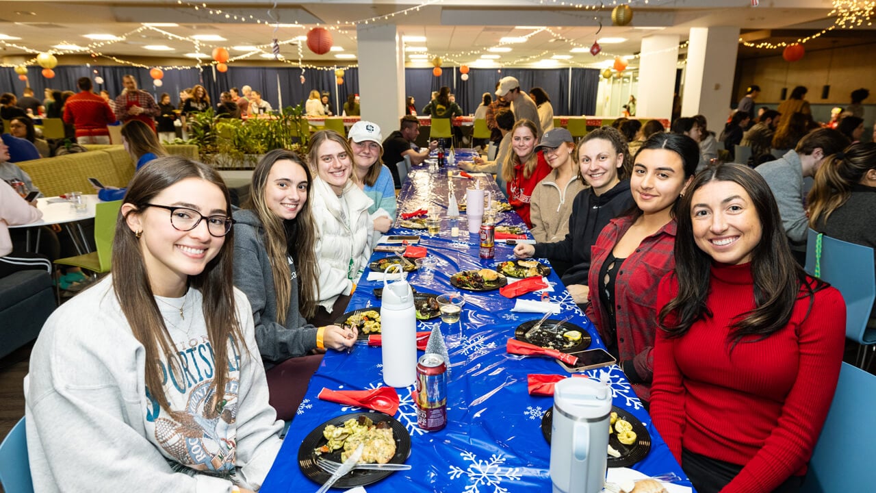 People sitting at a table smiling at the camera