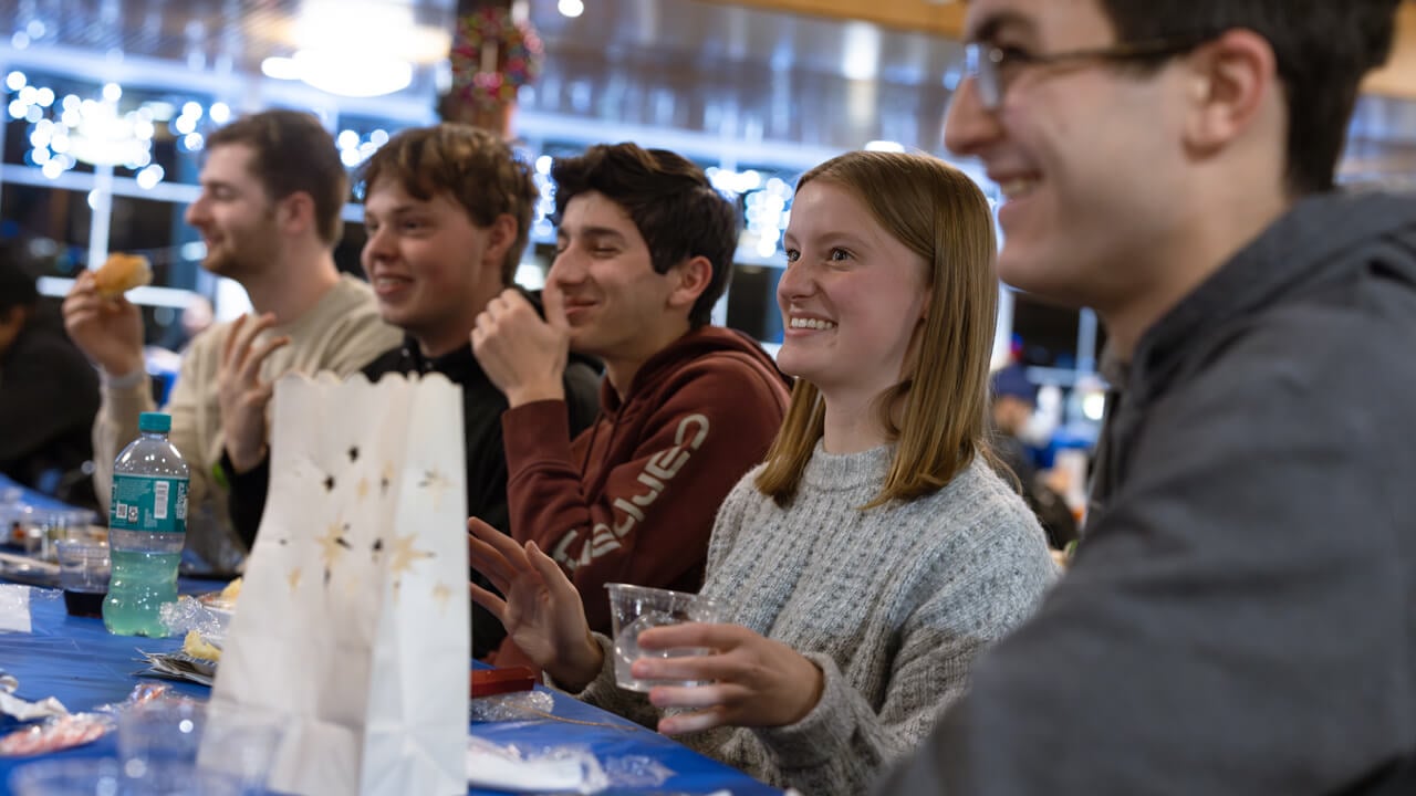 Individuals sitting at a table eating