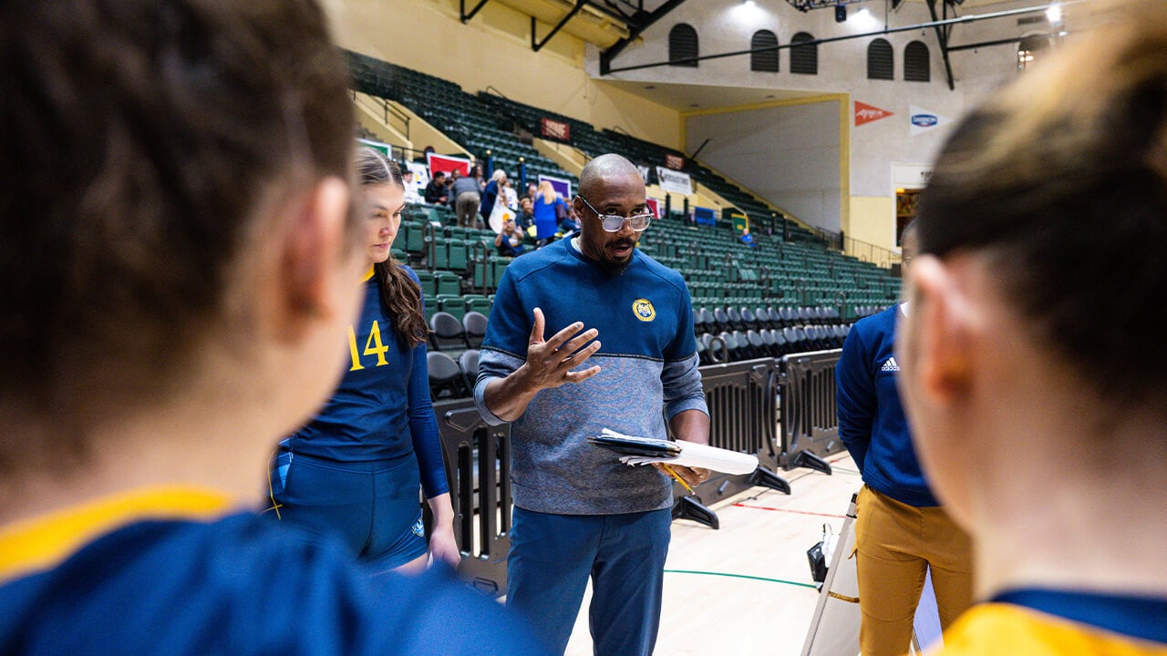 Coach Kyle Robinson speaking to the girls in a pre-game huddle.