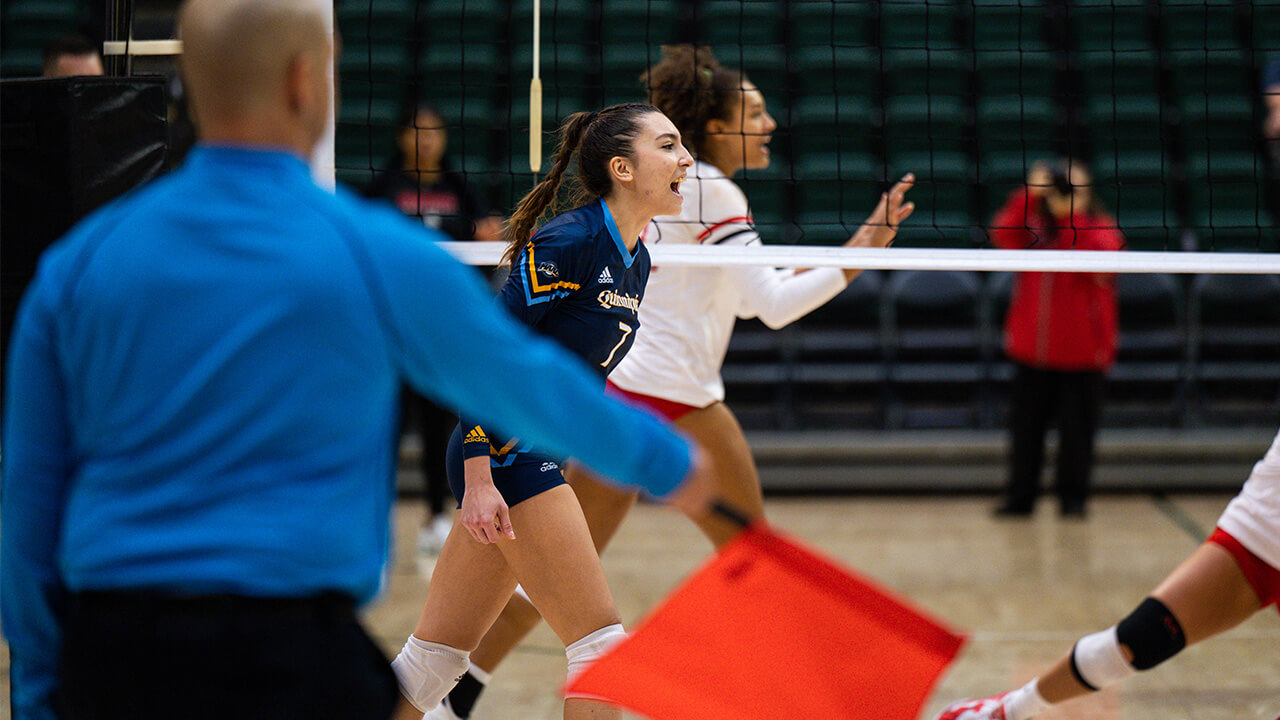 Yagmur Gunes screams in excitement after scoring a point, a ref's flag signals 