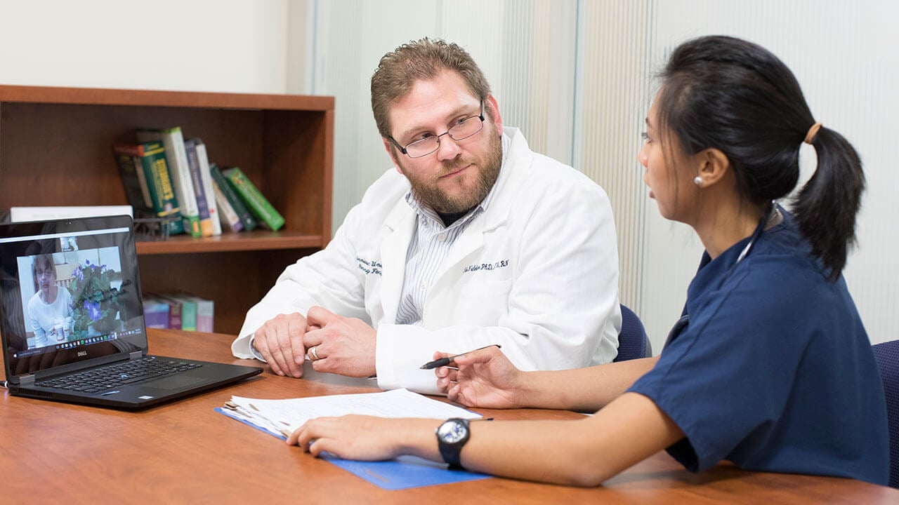 nurse talking with a doctor at a desk