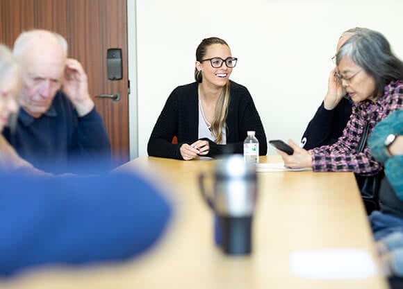 woman talking with elderly people around a table