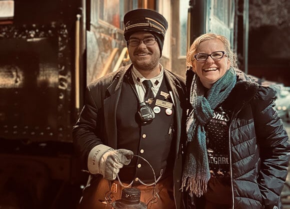 Quinnipiac student train conductor in front of North Pole Express.