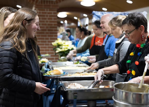 Faculty and staff serving students food