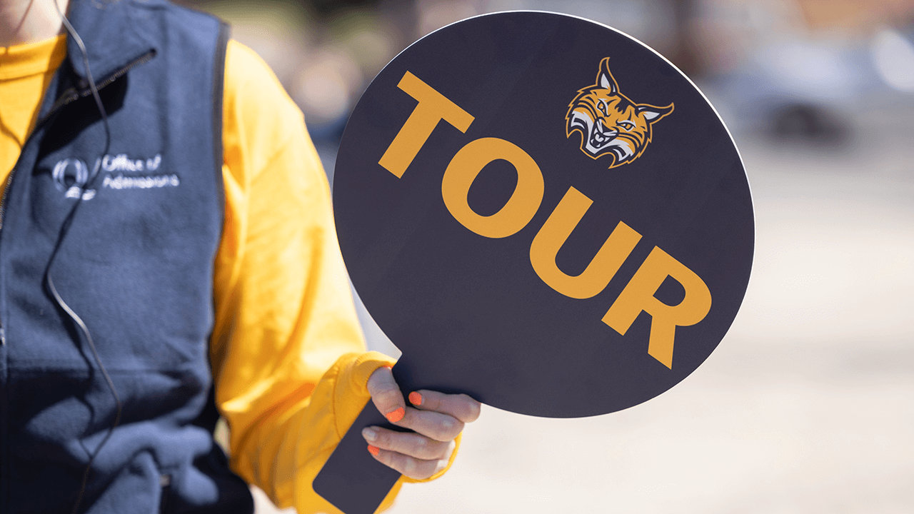 A person holds a tour sign