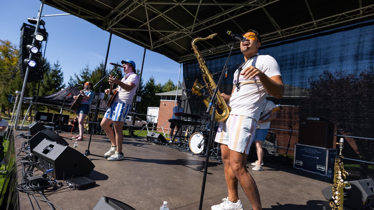 People stand on stage playing instruments