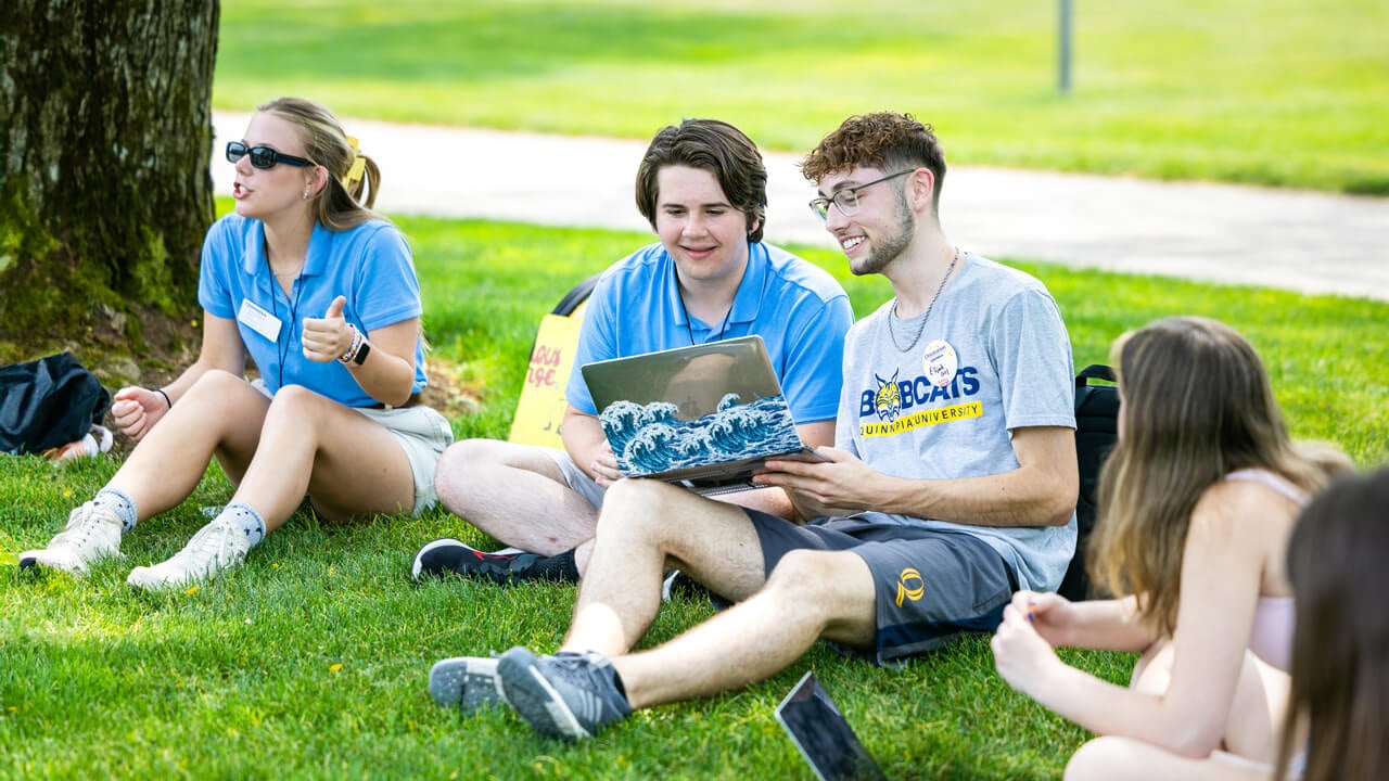 Students look at laptop together