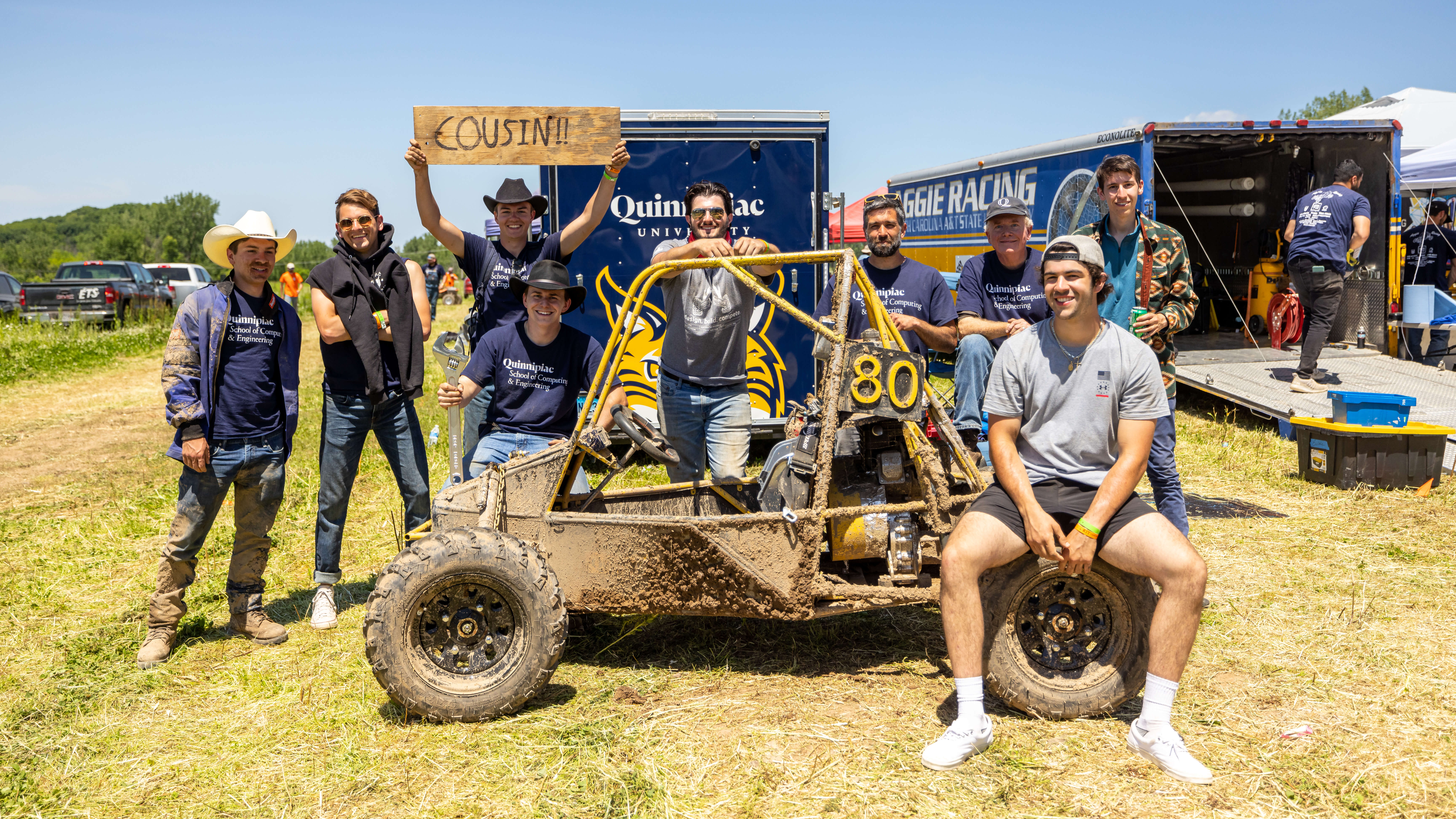 Students and faculty pose next to car