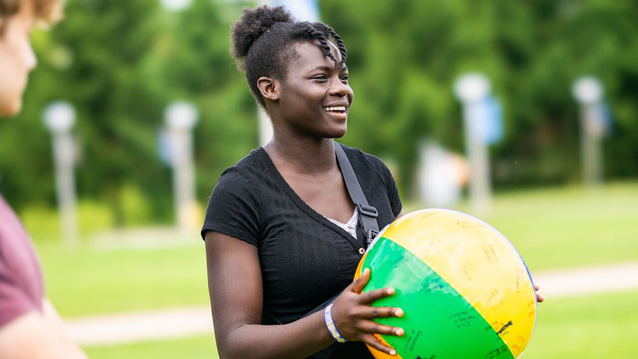 first-year quinnipiac student holding a beach ball during Orientation