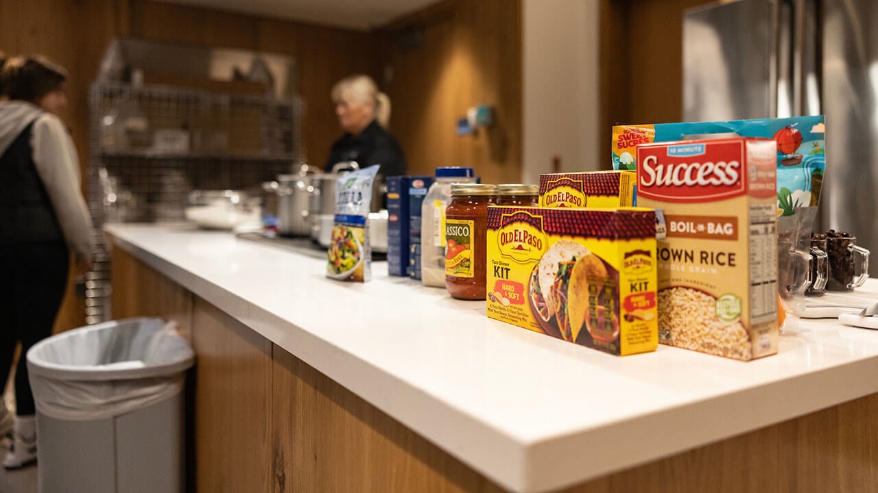 the supplies needed for the course, including bagged rice, taco shells, and a variety of seasonings, are on a counter