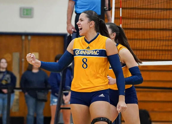 Volleyball player pumps fist in excitement.