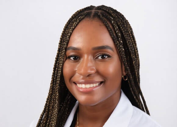 Okeroghene Rufin smiles in a close-up headshot wearing a medical coat.