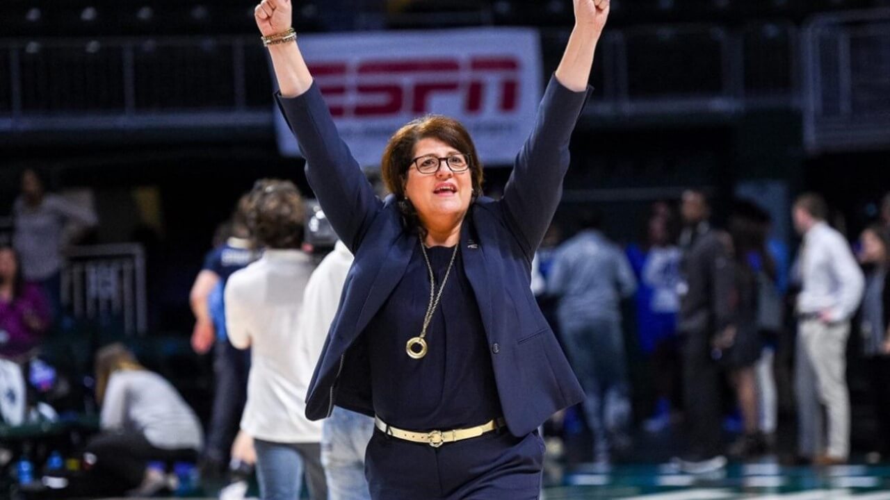 Fabbri raises her arms in celebration on the basketball court.