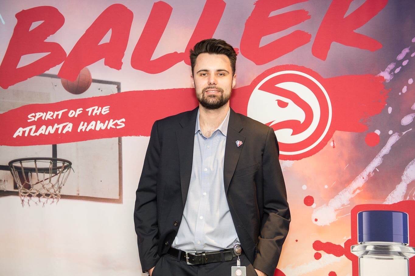 Chris Thorkilsen smiles in front of Atlanta Hawks photobackdrop