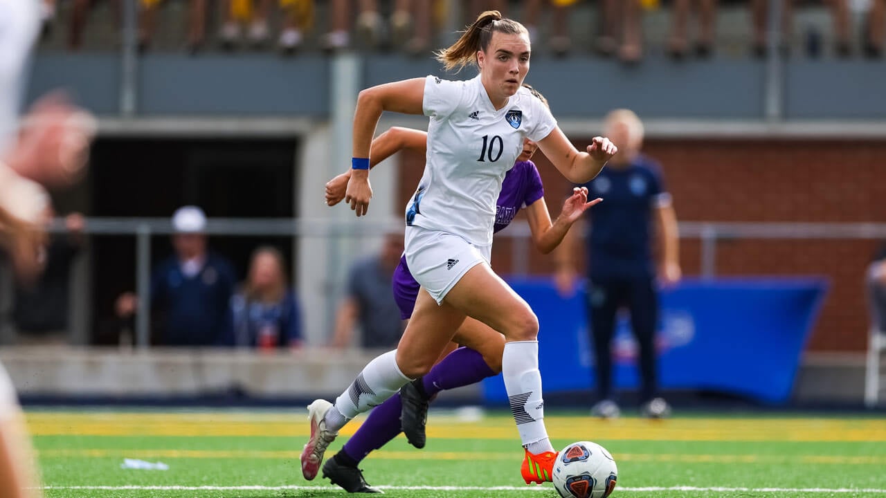 Rebecca Cooke running on the soccer field during a game.