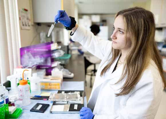 Carly Sipper conducts research in a lab.