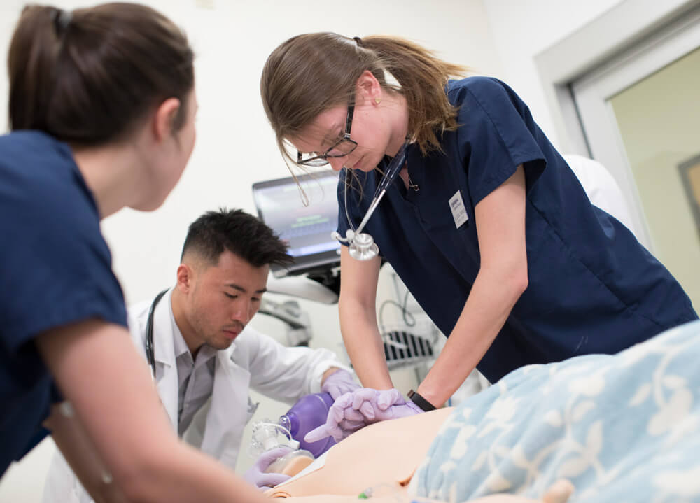 3 students preforming cpr on a high-fidelity mannequin