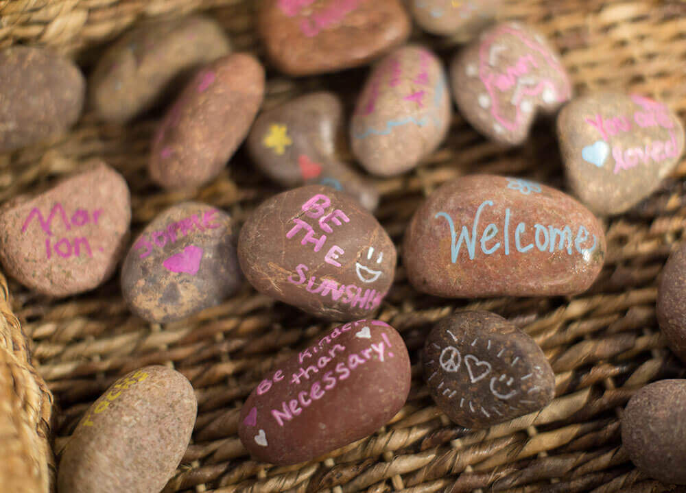 Close-up shot of tiny rocks painted with messages of positivity like 