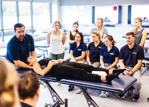 Quinnipiac DPT students watch as their professor gives a demonstration