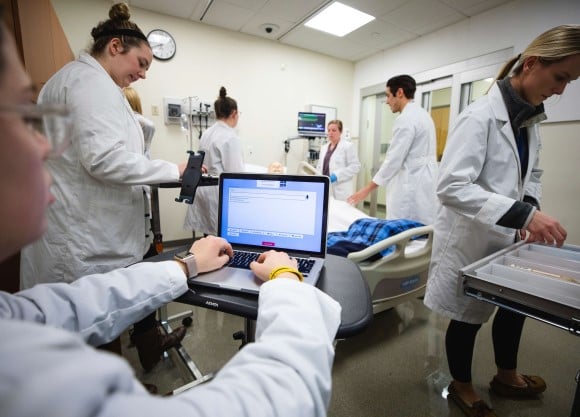 Quinnipiac Nursing student Abigail Contino using an app developed by Quinnipiac’s School of Engineering Software Engineering students for timekeeping, tracking, and recording cardiac events, which they developed for the School of Nursing during a cardiac arrest simulation, in the Simulation Suite