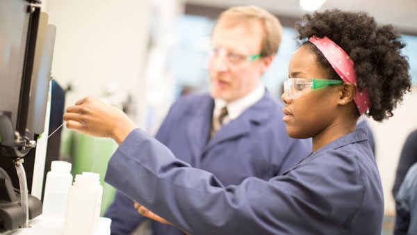 An undergraduate student uses equipment in an engineering lab