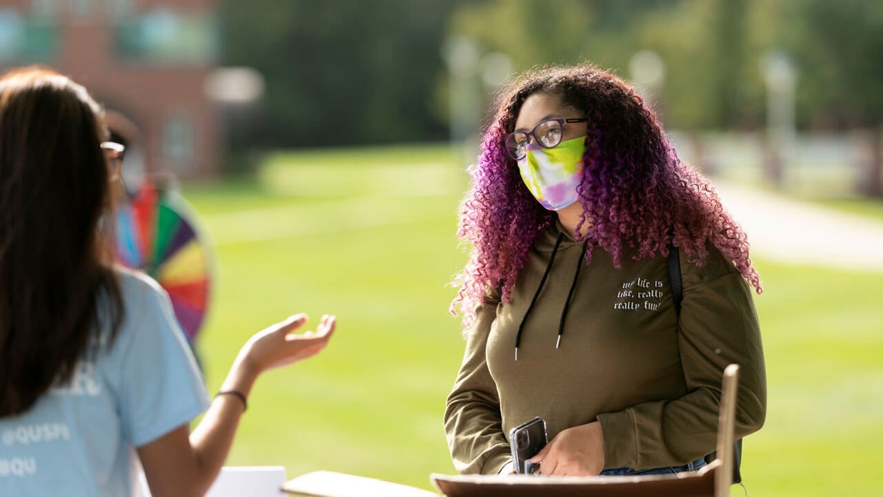 Students wearing masks interact during involvement fair