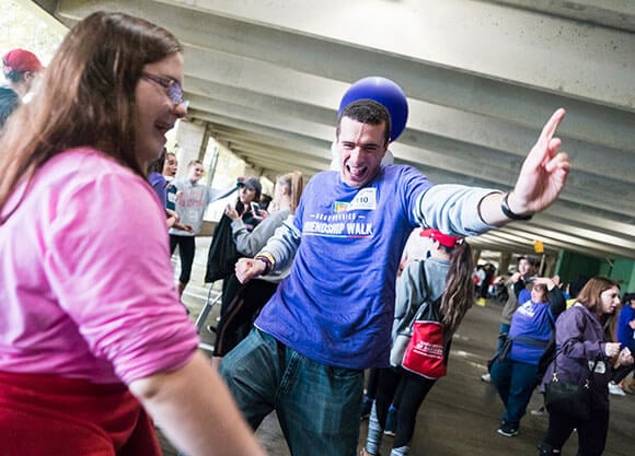 Student volunteers and Best Buddy participants laugh and dance during a Best Buddies event