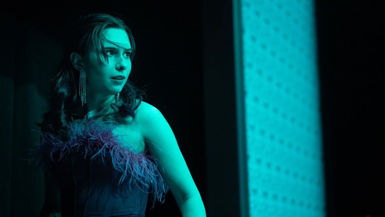 A female student actress looking over her shoulder with blue ambient lighting